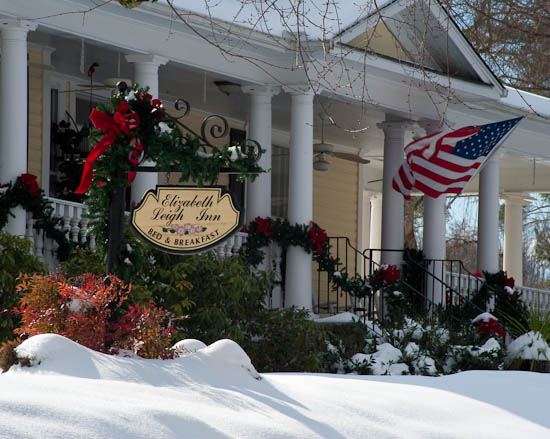 The Elizabeth Leigh Inn sign hanging by the front porch, decorated for winter