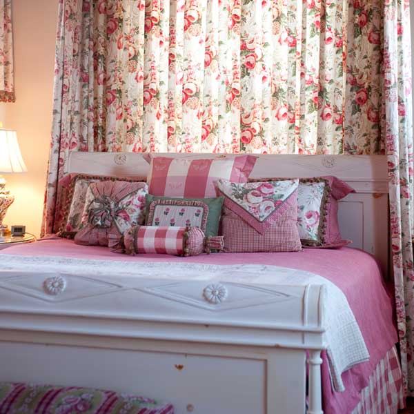 The Sage Room sleigh bed seen from the foot of the bed, with floral curtains
